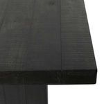 Close-up of textured black pine wood grain on the tabletop corner