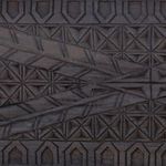 Detailed close-up of intricate wood carving pattern on trunk's front panel