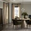 Globe pendant light hanging above round dining table in elegant room with armchairs and large windows