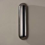 distant view of wall sconce mounted on matte beige wall without light illuminated