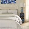 Aaron end table styled next to bed showing room context with bedding and abstract artwork