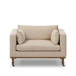 Harlin Chair with elongated bench seat, boxy arms, wheat neutral performance fabric, turned oak legs with brass casters