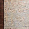 Faye Santa Fe blue rug with distressed traditional motifs in soft beige, blue, and orange tones on wood floor