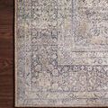 Wynter rug corner on dark wood floor showing intricate floral and geometric edge details