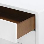 Partially opened drawer showing the natural wood interior and smooth white linen finish exterior