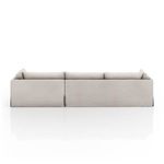 Back view of left arm-facing sectional with visible slipcover seams and pleats