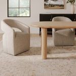 Two Barrow Rolling Dining Chairs placed beside a light wood dining table in carpeted room