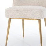 Close-up of cushioned seat and upper portion of satin brass hairpin legs
