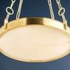 Lit chandelier with alabaster diffuser softly glowing, aged brass frame and chain details