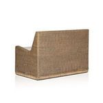 Side corner close-up showing woven rattan armrest and beige cushioned seat