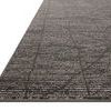 Close-up angled view highlighting the low pile and detailed texture of the charcoal and ivory rug
