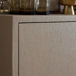 Close-up of antique brass round cabinet door knobs on textured light finish surface