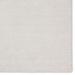 Top edge of ivory rug highlighting fine horizontal stripe texture and reinforced edges