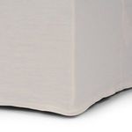 Close-up view of straight center seam at base of linen slipcover draped over bench corner.