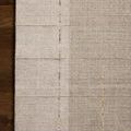 Top-down view showing rug placed on dark hardwood floor emphasizing color blocks and subtle line details