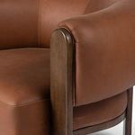 Detail of wood frame edge next to padded leather arm cushion