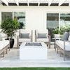 Outdoor patio arrangement with Laguna Sofa and chairs in neutral tones with fire pit and plants