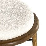 Extreme close view highlighting boucle fabric texture and stitching on cushion edge