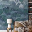 Wall mural wallpaper with abstract watercolor pattern in shades of blue and green, shown in a living room setting
