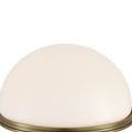 Glossy white glass dome shade close-up with brass rim and vertical grooves on brass column