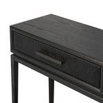 Close-up on woven textured drawer front with curved black metal handle