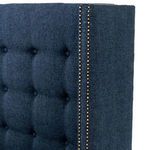 Edge view of brass nailhead trim on headboard with mattress edge visible