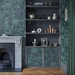 Wallpaper installed in room with fireplace, shelves, and wooden herringbone floor