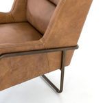 Close-up showing metal frame connection to the leather upholstered arm and side panel