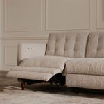 Living room setting with sofa reclined and styled with neutral rug, art, and surrounding furniture