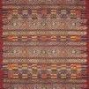 Rectangular red rug with abstract and tribal-inspired patterns in multicolored textured yarns, durable for indoor and outd...
