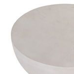 Partial angled view of round table top showing subtle surface texture and soft rounded edges