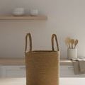 Natural bamboo basket placed on kitchen counter with wooden utensils and light neutral background