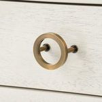 Macro close-up of brass drawer pull showing smooth circular design and finish