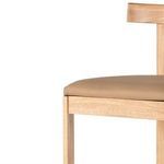 Partial close-up on rounded leather seat edge and wood frame joint