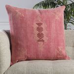 Shazi throw pillow positioned on an armchair with room decor visible in soft focus