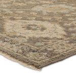 Close-up angled view showing the rug's low pile texture and cream fringe edge