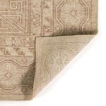 Close-up corner fold of the rug showing texture and backside weave pattern