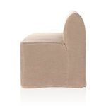 Side close-up of slipcover fabric seam at armrest curve