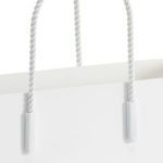 Close-up of twisted rope handles attached to matte white magazine tote