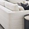 Close-up on sectional armrest and back cushions styled with dark accent pillows in bright living space