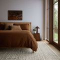 Tallulah Mist Ivory Rug styled in bedroom setting under bed near large window and wooden nightstand