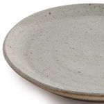 Rustic dining scene including speckled clay dinner plates with mugs, pitchers and bowls on wooden table