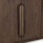 Close-up detail of brass oval door pull set into a recessed wood feature on buffet door