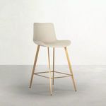 Three-quarter angle of stool placed on light gray floor against white textured wall