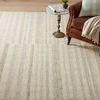 Top angle of rug beside leather armchair and small round brass accent table