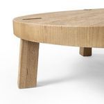 Close side angle focusing on tapered oak leg against thick round tabletop