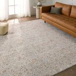 Rug styled in a living room setting under leather sofa with wood flooring and natural light