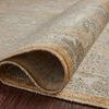 Curled corner of rug showing dense pile and backside weave on dark wood floor
