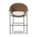 Outdoor bar stool with a curvy woven frame in brown and a white upholstered cushion on black iron legs