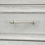 Detail of polished nickel drawer pull mounted on textured gray-washed grasscloth panel